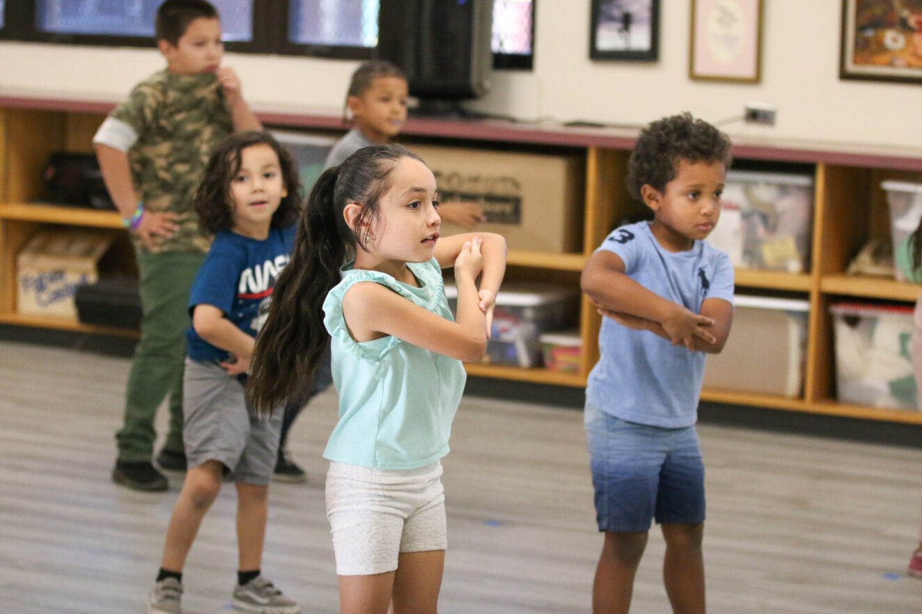 Students learn a dance.