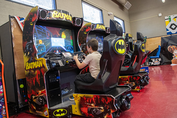 A little boy plays a Batman arcade game