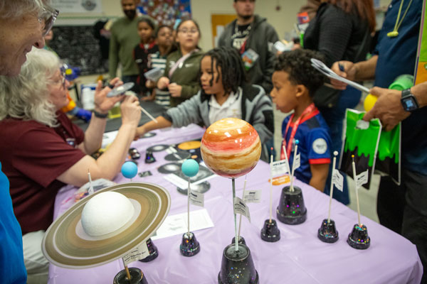 Children line up to learn about the planets